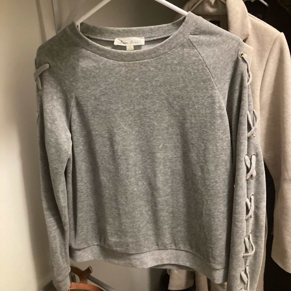 Grey crewneck top with crossover sleeve design